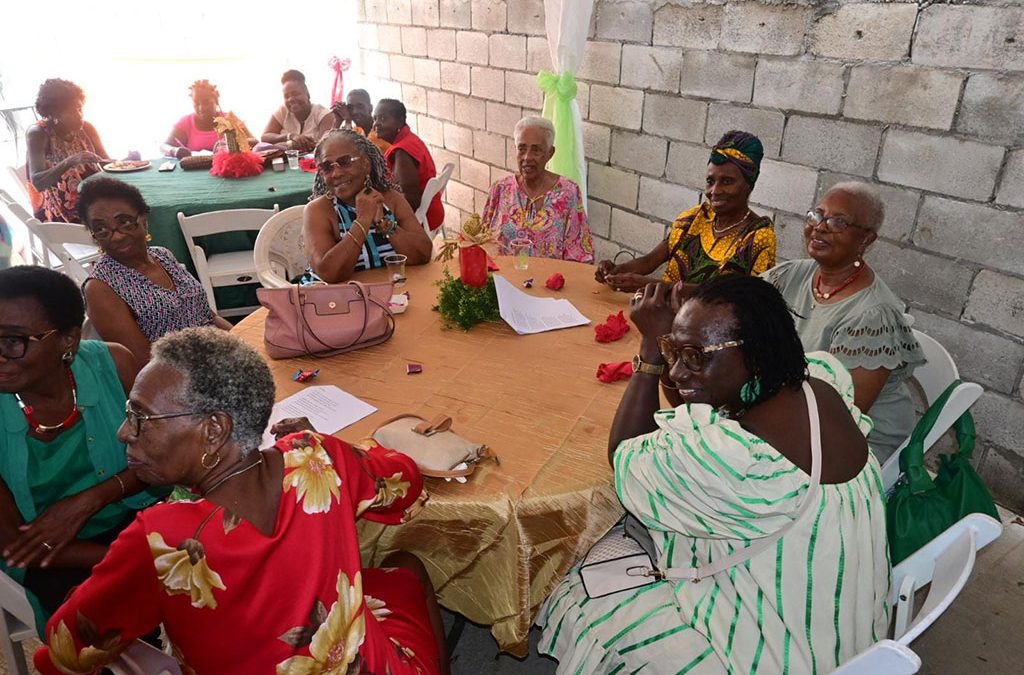Colorfully dressed ladies sitting at a round table